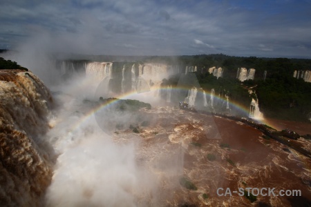Iguazu river tree spray waterfall sky.